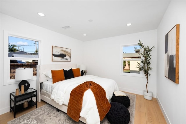 bedroom with visible vents, baseboards, light wood-type flooring, and recessed lighting