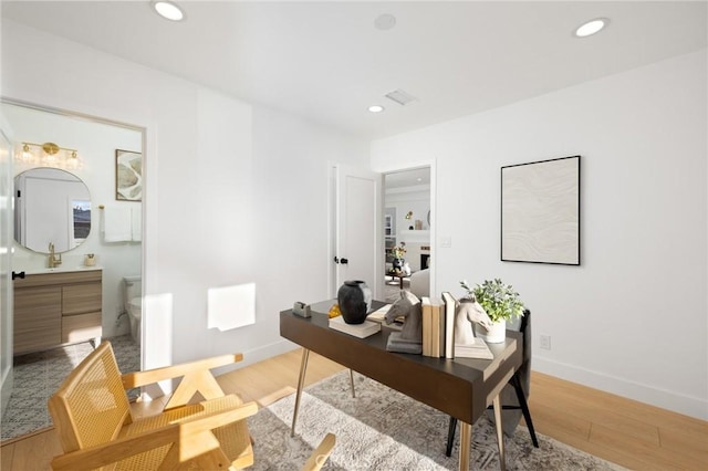 home office with recessed lighting, light wood-style flooring, and baseboards