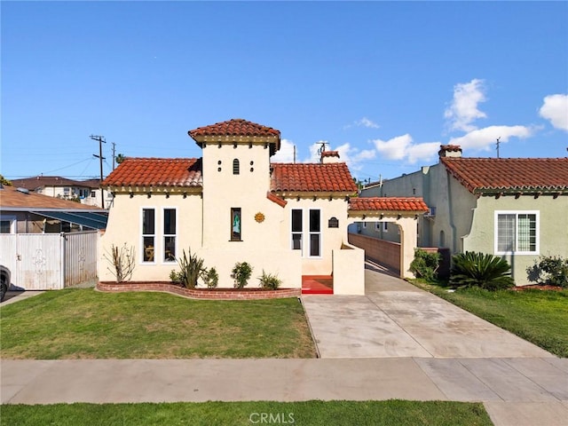 mediterranean / spanish house featuring concrete driveway, stucco siding, a front lawn, a tile roof, and fence