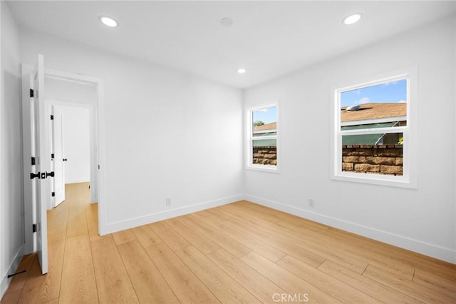 empty room with recessed lighting, light wood-style floors, and baseboards