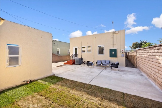 back of property featuring central AC, outdoor lounge area, a fenced backyard, stucco siding, and a patio