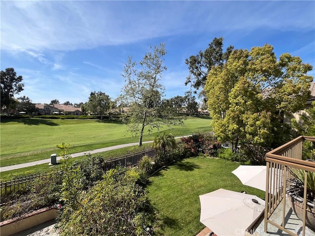 view of yard featuring golf course view, fence, and a patio