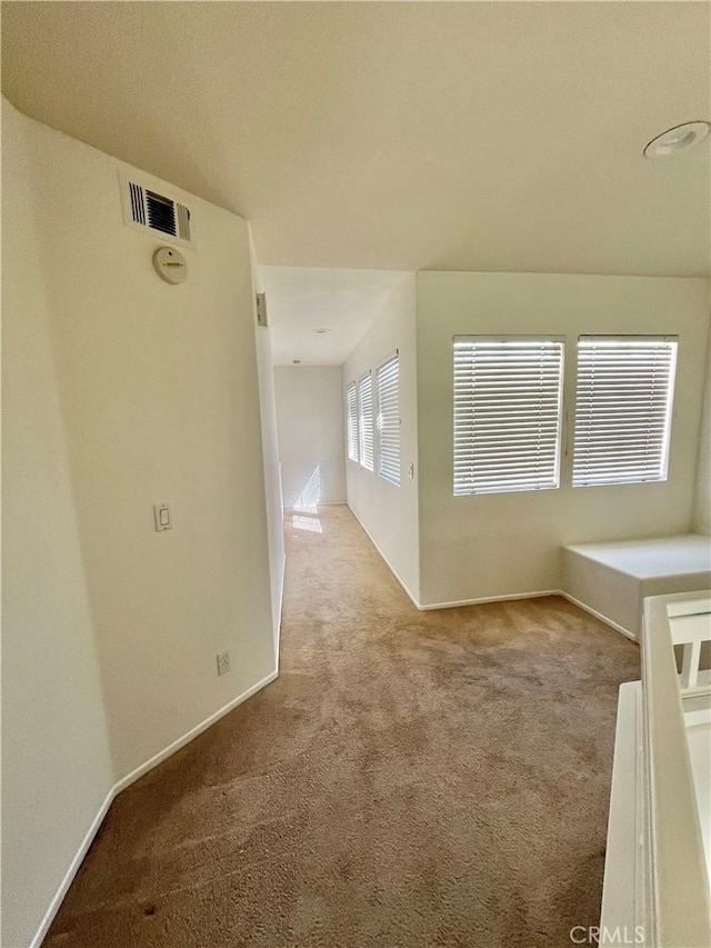 carpeted empty room with visible vents and baseboards