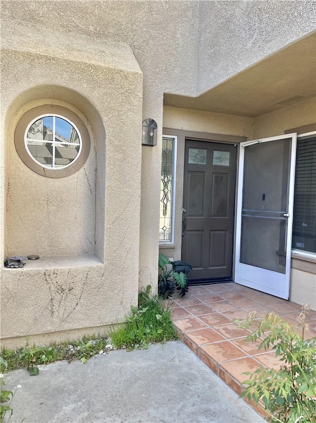 doorway to property featuring stucco siding