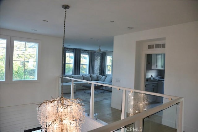 living area featuring a healthy amount of sunlight, separate washer and dryer, wood finished floors, and visible vents