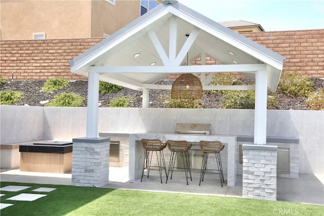 view of patio / terrace featuring exterior kitchen, a gazebo, a grill, and outdoor wet bar