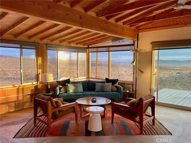 sunroom / solarium featuring a healthy amount of sunlight, a mountain view, and beam ceiling