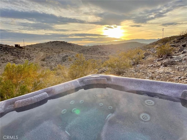 exterior space with a mountain view and a hot tub