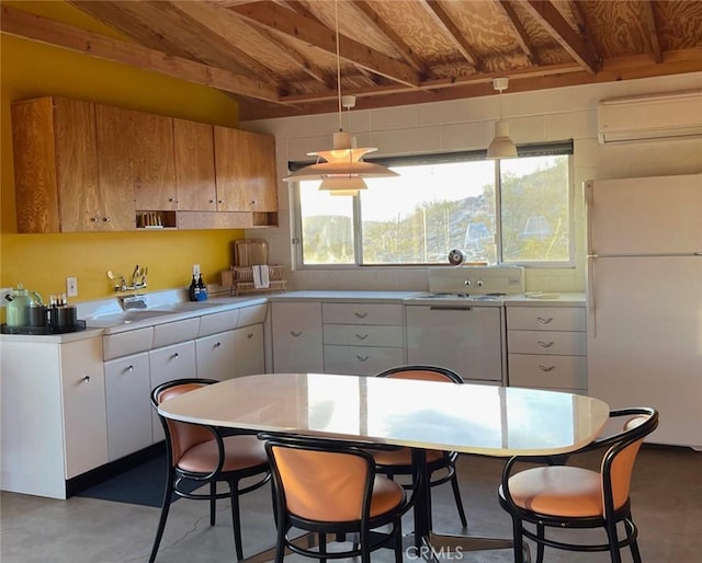 kitchen featuring freestanding refrigerator, finished concrete floors, beamed ceiling, light countertops, and a wall mounted AC