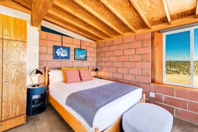 63465 Belmont St, Joshua Tree, CA 92252 - bedroom with concrete block wall, concrete flooring, and lofted ceiling with beams