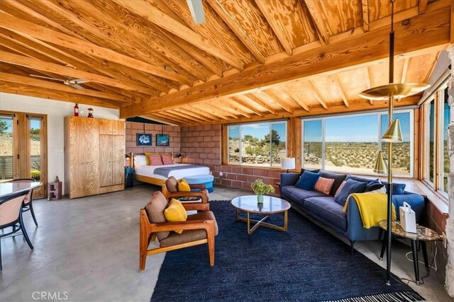 63465 Belmont St, Joshua Tree, CA 92252 - living room with finished concrete floors, beamed ceiling, and a healthy amount of sunlight