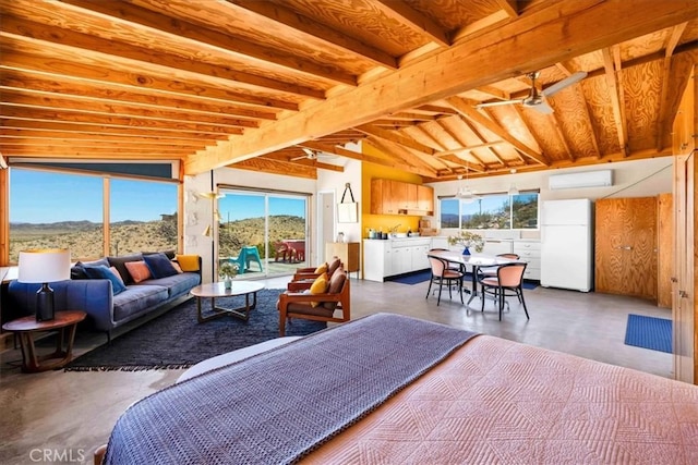 63465 Belmont St, Joshua Tree, CA 92252 - bedroom with a wall mounted air conditioner, concrete flooring, a mountain view, freestanding refrigerator, and access to outside