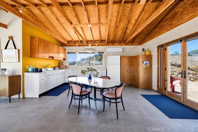 63465 Belmont St, Joshua Tree, CA 92252 - dining room featuring a wall mounted AC, finished concrete flooring, wood ceiling, and vaulted ceiling