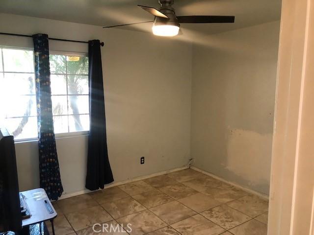 spare room featuring baseboards and a ceiling fan