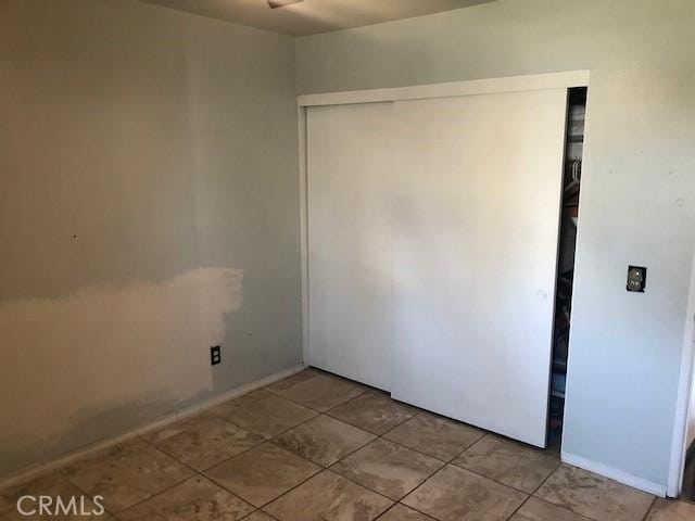 unfurnished bedroom featuring tile patterned floors and a closet