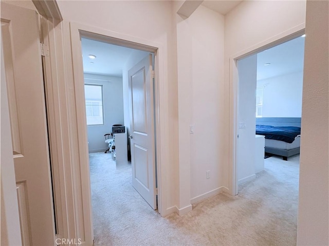 hall with baseboards and carpet floors