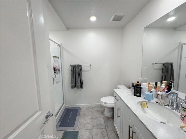 bathroom with visible vents, toilet, vanity, baseboards, and a stall shower