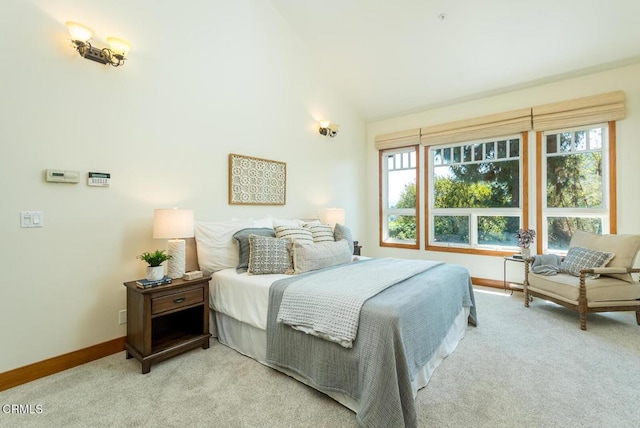 bedroom featuring light carpet, baseboards, multiple windows, and vaulted ceiling