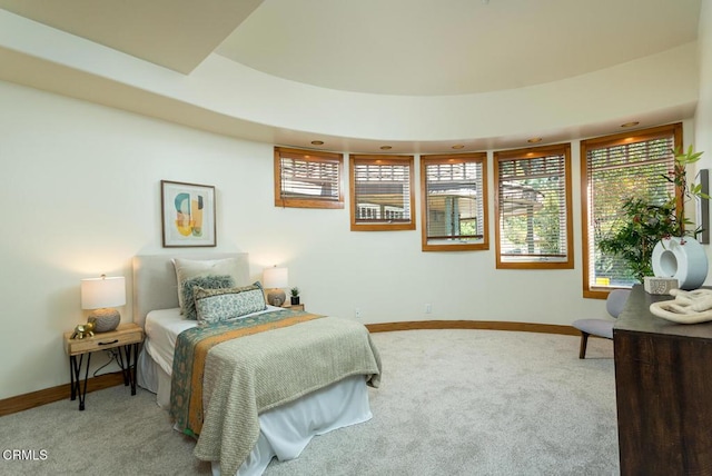 carpeted bedroom with multiple windows and baseboards