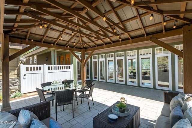 view of patio featuring a gazebo, outdoor dining space, and fence
