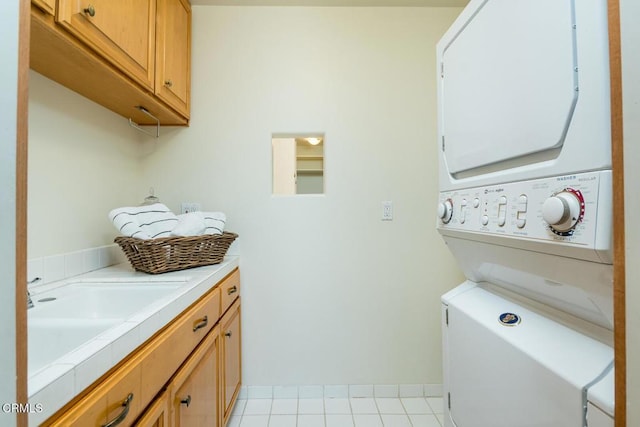 washroom featuring stacked washer and clothes dryer and cabinet space