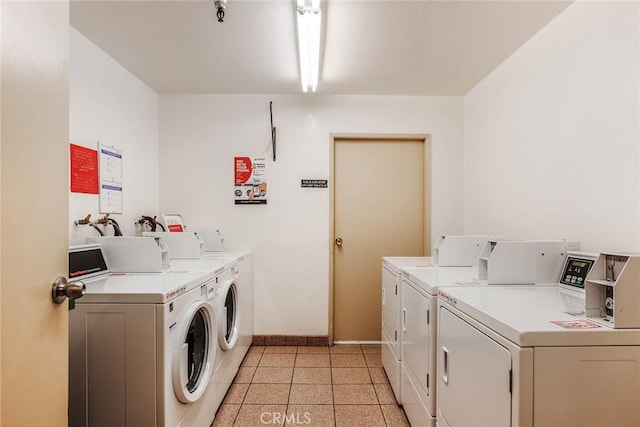 community laundry room featuring baseboards and washing machine and clothes dryer