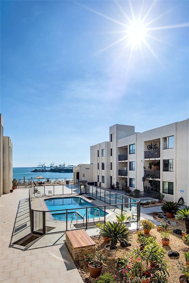 pool with a water view and fence