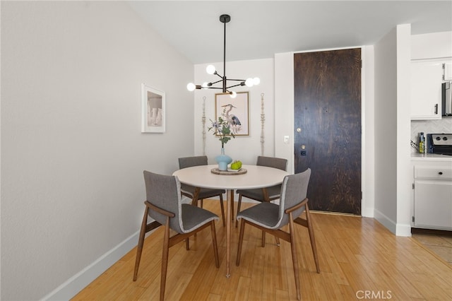 1140 E Ocean Blvd Unit 220, Long Beach, CA 90802 - dining room featuring light wood-style floors, a chandelier, and baseboards