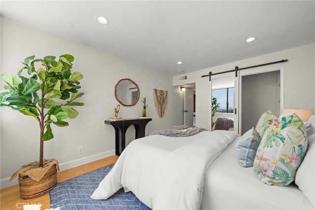 1140 E Ocean Blvd Unit 220, Long Beach, CA 90802 - bedroom featuring a barn door, wood finished floors, baseboards, and recessed lighting