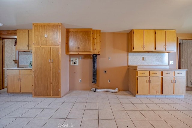 kitchen with tasteful backsplash, light tile patterned floors, and light countertops