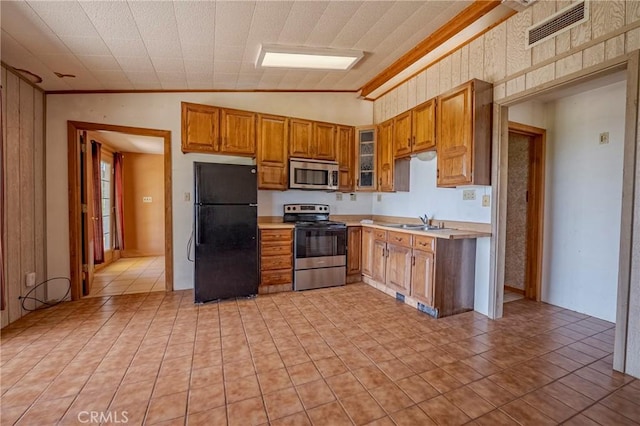 kitchen with brown cabinetry, visible vents, appliances with stainless steel finishes, light countertops, and lofted ceiling
