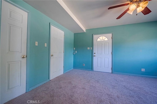 foyer featuring carpet, baseboards, and ceiling fan