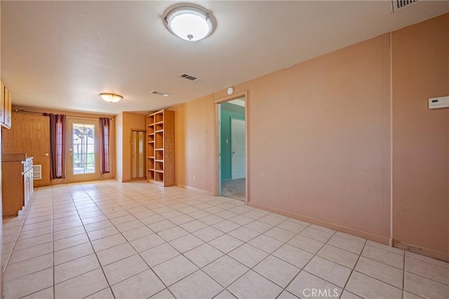 empty room with visible vents, baseboards, and light tile patterned flooring