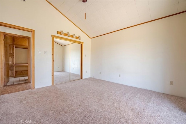 unfurnished bedroom with a closet, vaulted ceiling, and carpet floors
