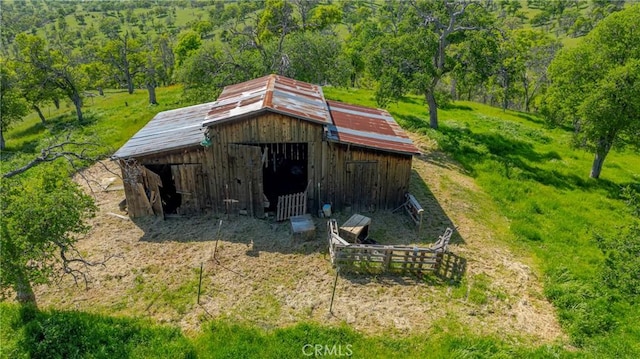 view of outdoor structure featuring an outbuilding and a forest view