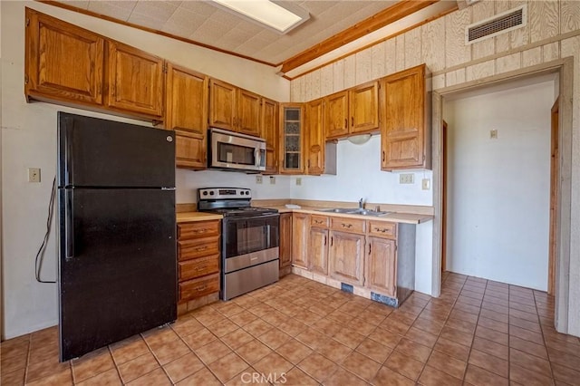 kitchen featuring light countertops, visible vents, lofted ceiling, stainless steel appliances, and a sink