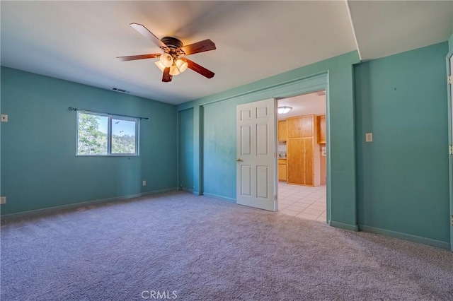 unfurnished bedroom with visible vents, baseboards, a ceiling fan, and light colored carpet