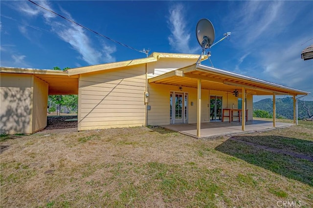 rear view of property featuring a patio and a yard