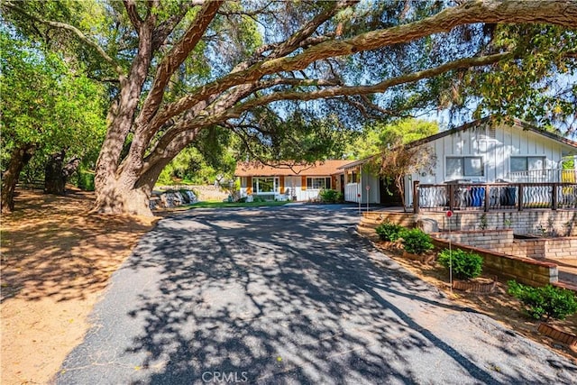 single story home featuring board and batten siding and aphalt driveway