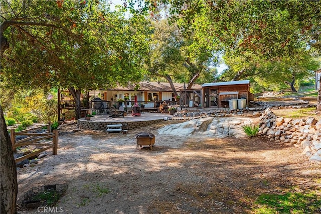 back of property with an outdoor fire pit and a patio