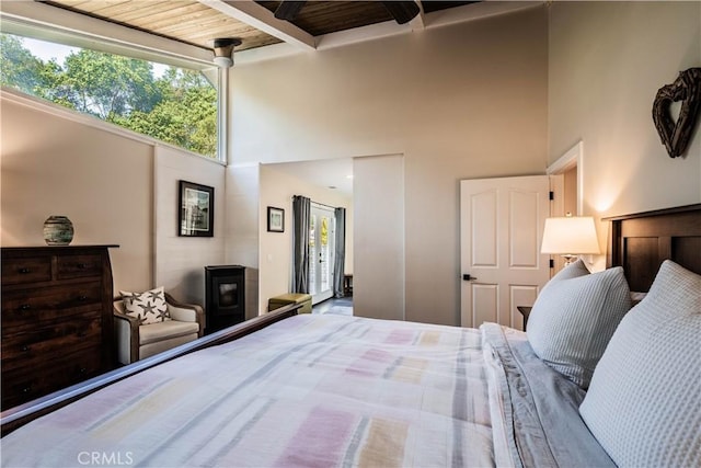 bedroom with a high ceiling and beamed ceiling