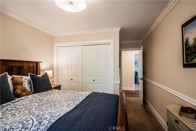 bedroom featuring dark carpet, crown molding, a closet, and baseboards