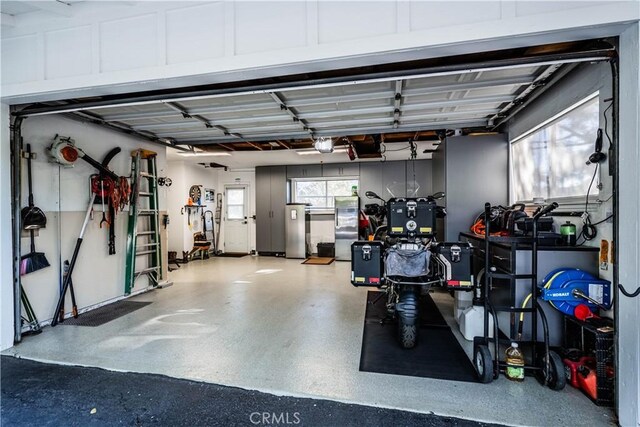 garage with a garage door opener and freestanding refrigerator