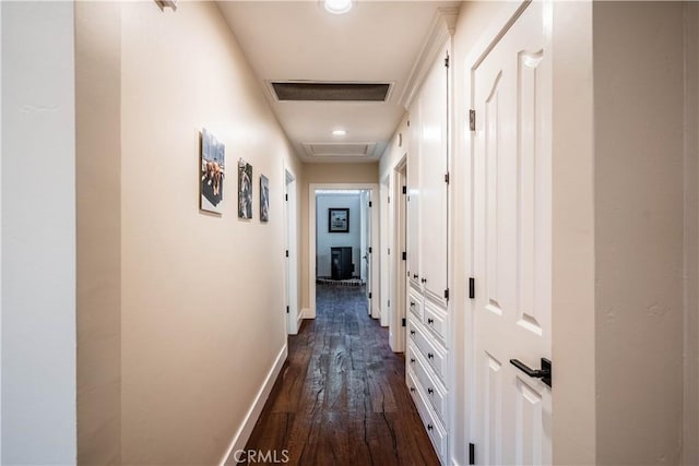 hall featuring dark wood-type flooring, baseboards, and visible vents