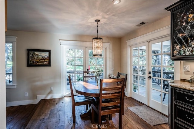 dining room with visible vents, baseboards, an inviting chandelier, and dark wood-style floors