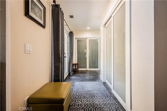 hallway featuring recessed lighting, visible vents, and baseboards