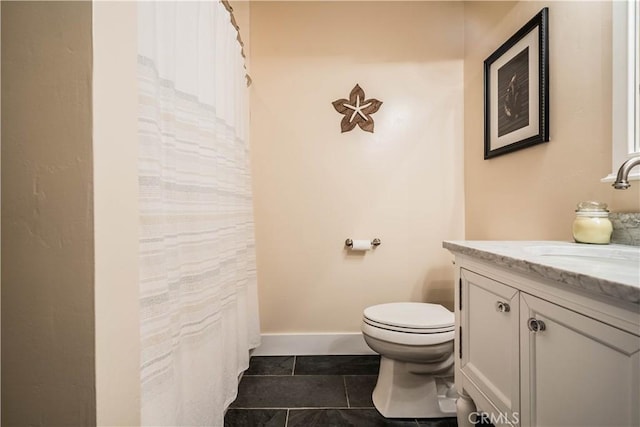 bathroom featuring tile patterned floors, toilet, vanity, and baseboards