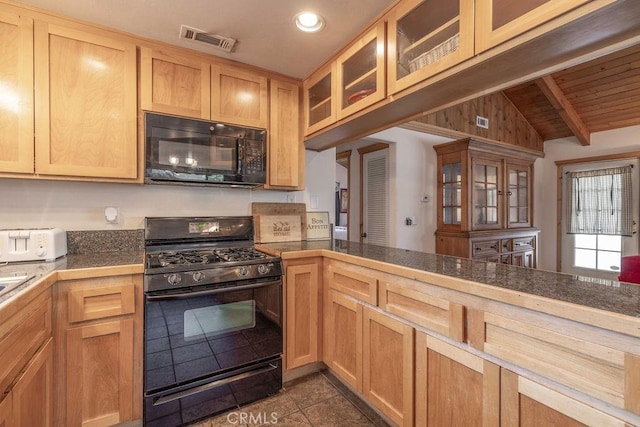 kitchen featuring glass insert cabinets, visible vents, black appliances, dark tile patterned floors, and vaulted ceiling with beams