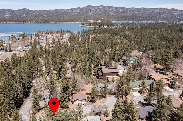 aerial view with a wooded view and a water and mountain view