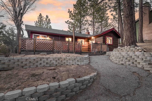back of property at dusk featuring a wooden deck